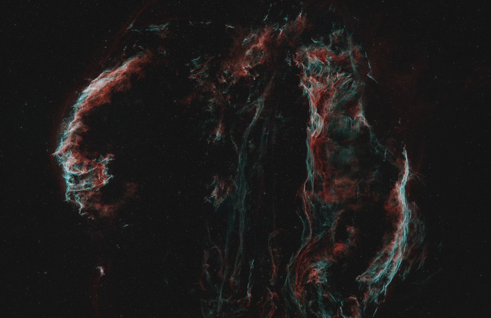 Cygnus Loop supernova remnant in red and teal filaments